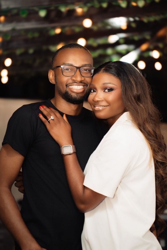 The couple embracing, smiling at the camera